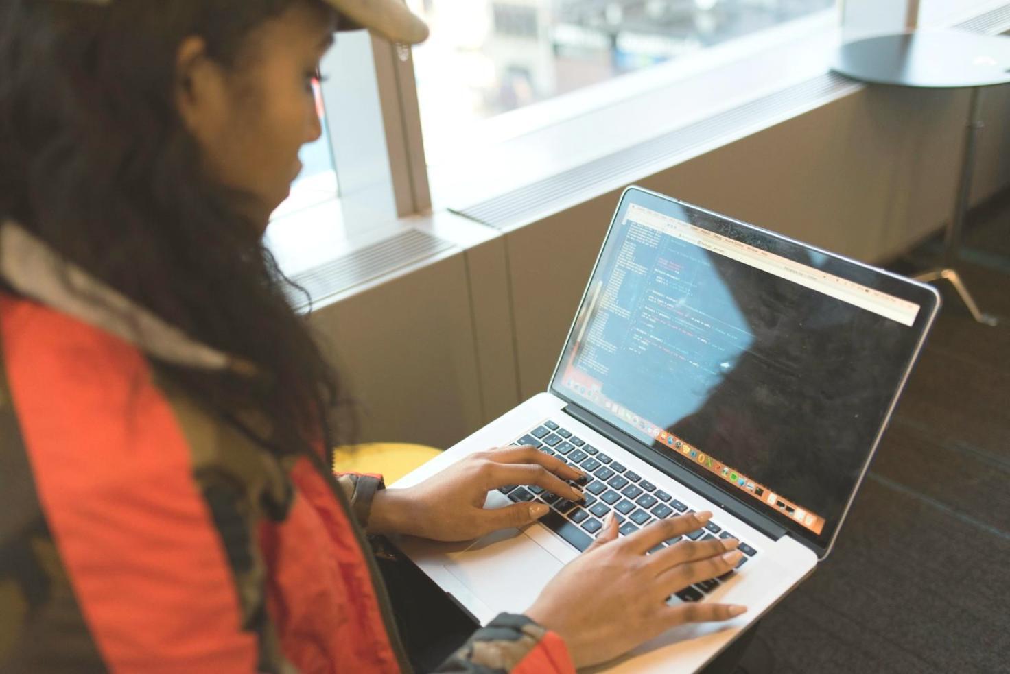Professional working on software testing certification with multiple monitors showing testing frameworks and documentation